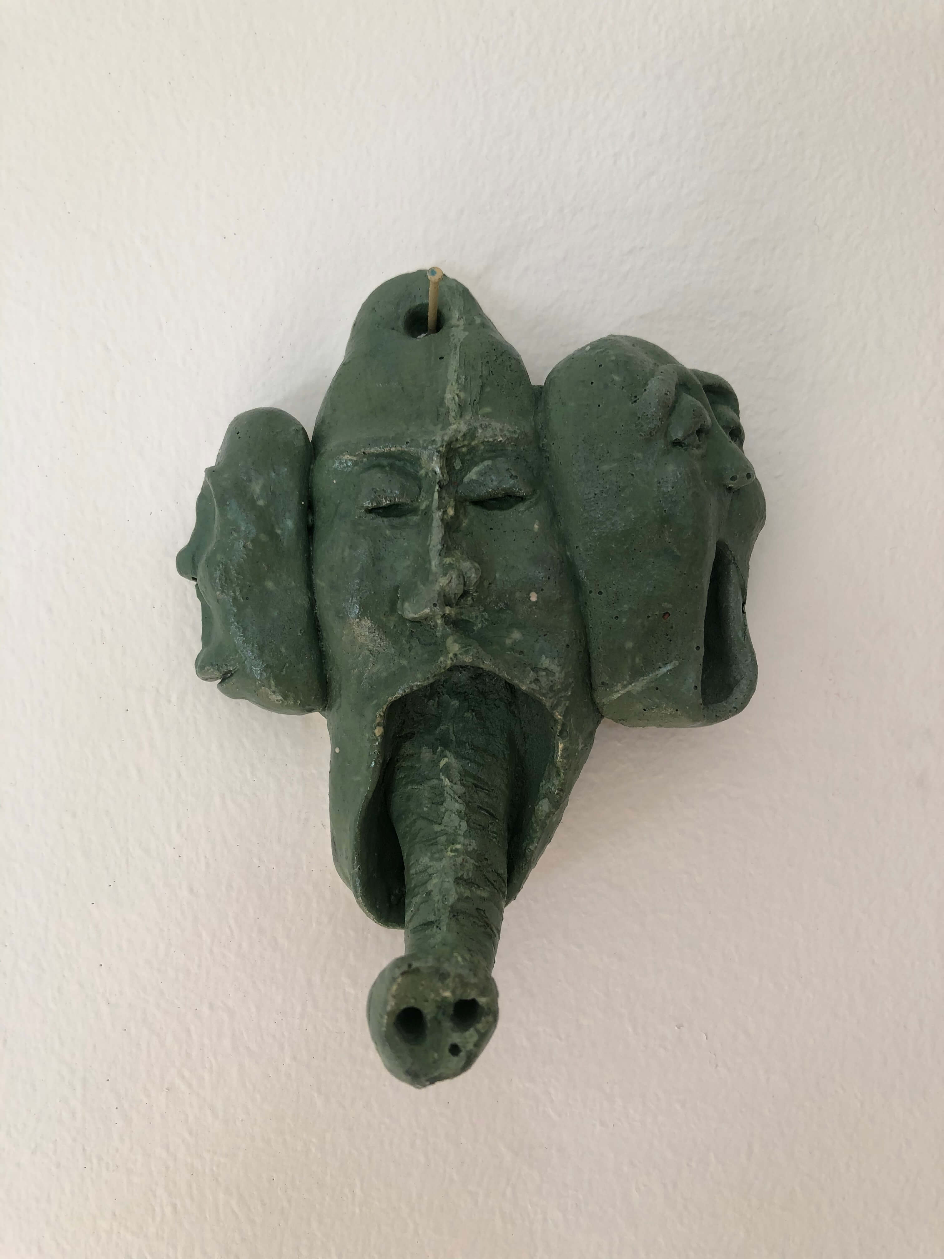 green coat hanger in a shape of face merged with elephant nose